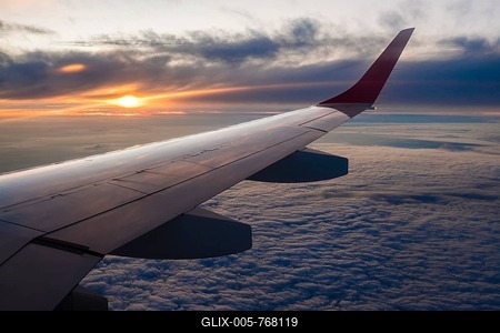 Wing of the airplane, flight over cloud cover, sunset-stock-foto
