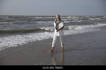 Male Best Ager walking on the beach of the North Sea in De Haan, Belgium, Europe-stock-foto