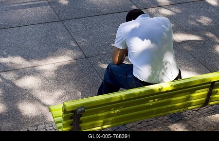 Man with bowed head sitting on a green park bench, Berlin, Germany, Europe-stock-foto