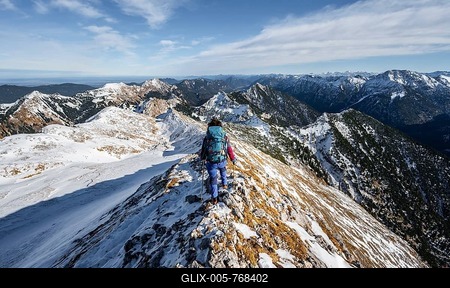 Mountaineer on the narrow rocky snowy ridge of the Ammergauer Hochplatte, view towards Lösertaljoch, view of mountain panorama, hiking to the Ammergauer Hochplatte, in autumn, Ammergauer Alps, Bavaria, Germany-stock-foto