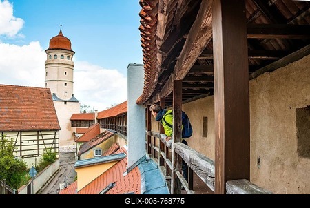 Young man on the old city wall, behind tower Deininger Tor, Nördlingen, Swabia, Bavaria, Germany-stock-foto