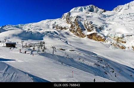 Skiers on the L舅gfluh ski slope in front of the snow-covered Alphubel, Saas-Fee, Valais, Switzerland-stock-foto