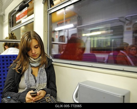 Young woman writing SMS while travelling on suburban train, Stuttgart, Baden-Wuerttemberg, Germany, Europe-stock-foto
