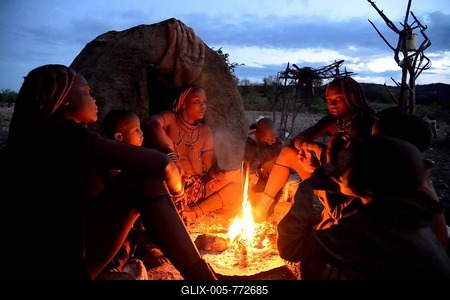 Himba women sitting around a fire in the early morning, Ombombo, Kaokoland, Kunene, Namibia-stock-foto