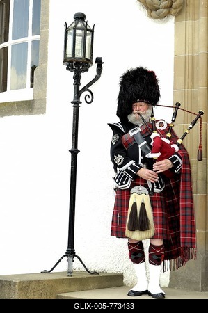 Bagpiper wearing a traditional Scottish costume with a bear skin hat and kilt at a castle entrance, Scotland, Great Britain, Europe-stock-foto