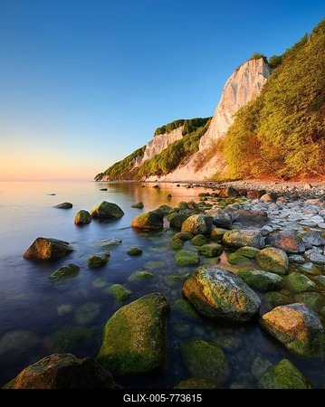 Sunrise at the Baltic Sea, chalk cliffs in the first morning light, boulders on the shore, in front the Königsstuhl, behind the Victoria view, Jasmund National Park, UNESCO World Heritage Site, Rügen Island, Mecklenburg-Western Pomerania, Germany-stock-foto