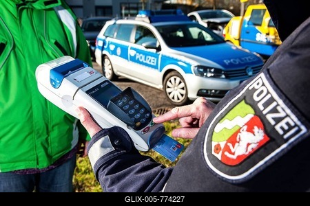 Police officer collecting an on-the-spot fine with a card reader, Germany-stock-foto