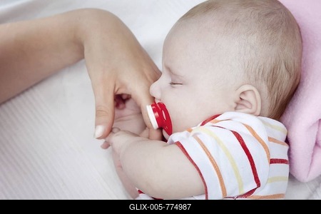 Three-month-old baby holding its mother's fingers while sleeping-stock-foto