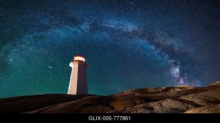 Lighthouse surrounded by rocks at night, lighthouse with lights on at night-stock-foto