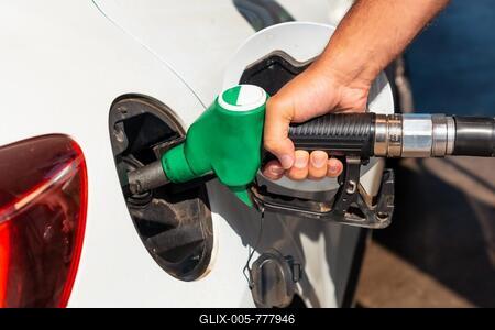 Close-up of a man's hand with the gun refueling gasoline or diesel fuel in a white car. Concept of transportation, energy crisis, oil crisis. Full tank in the midst of a price crisis at the gas pump-stock-foto