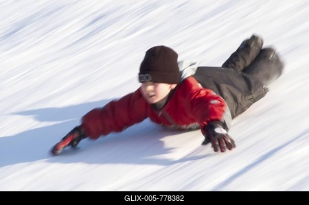 Boy sliding on his belly downhill-stock-foto