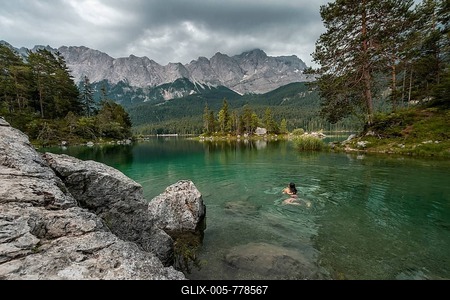 Woman swimming in the lake, view of Eibsee lake in front of Zugspitze massif with Zugspitze, cloudy, Wetterstein range, near Grainau, Upper Bavaria, Bavaria, Germany-stock-foto