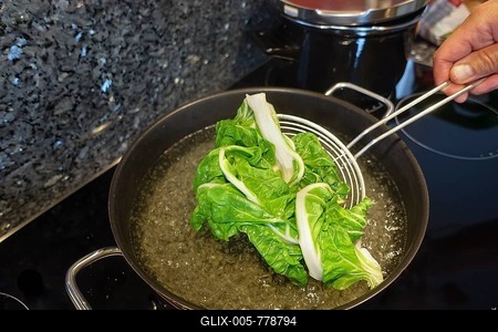 Swabian cuisine vegetarian, blanching chard, preparing chard runner, slotted spoon, man's hand, Germany-stock-foto