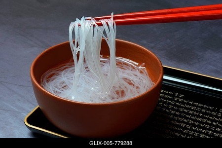 Asian glass noodles on chopsticks over bowl, Germany-stock-foto