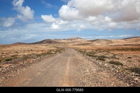 Dirt road and desert-like landscape with clouds in Tindaya, Fuerteventura, Canary Islands, Spain-stock-foto
