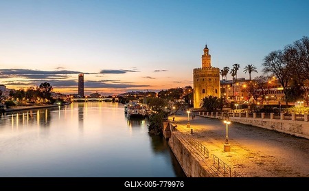 View over the river Rio Guadalquivir with Torre del Oro, promenade and Puente de Triana, in the back Torre Sevilla, sunset, blue hour, Sevilla, Andalusia, Spain-stock-foto