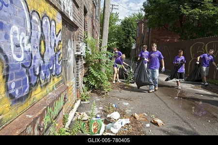 High school aged volunteers from St. Mary of the Hills Catholic church in Rochester Hills clean trash and debris from an alley in Detroit's Corktown neighborhood, Detroit, Michigan, USA-stock-foto