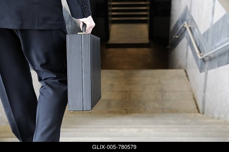 Businessman carrying a briefcase going down stairs to a subway station, rear view-stock-foto