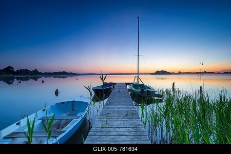 Morning glow at Schaalsee, wooden jetty with boats and reeds, Schaalsee Biosphere Reserve, Mecklenburg-Western Pomerania, Germany-stock-foto