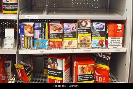 Germany, July 2019: Shelf with tobacco packs for rolling cigarettes with warning labels on them in German supermarket-stock-foto