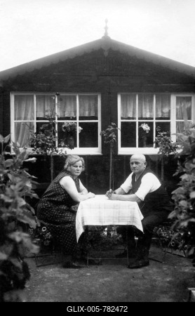 Couple, older couple sitting in the allotment garden at the table in front of the arbour, around 1920, Germany-stock-foto