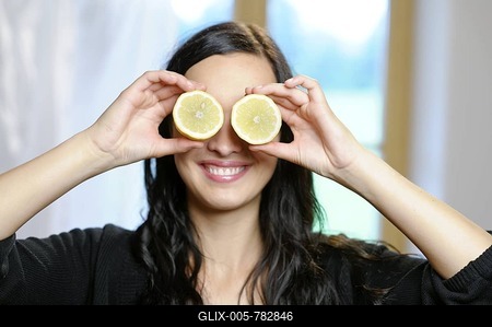 Young women holding slices of lemon in front of her eyes, vitamin C-stock-foto