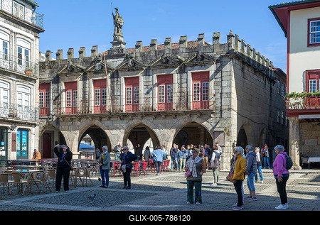 Tourist group viewing historic buildings in Largo da Oliveira square, city of Guimaraes, northern Portugal-stock-foto