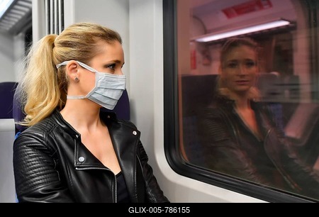 PHOTOMONTAGE, Woman with face mask, sitting in train, reflected in the window of the S-Bahn WITHOUT face mask, Corona crisis, Stuttgart, Baden-Württemberg, Germany-stock-foto