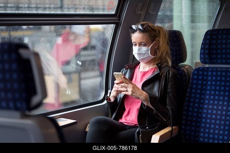 Woman with a face mask, sitting in Zug, on her mobile phone, Corona crisis, Stuttgart, Baden-Württemberg, Germany-stock-foto