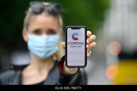 Woman with face mask, showing smartphone with Corona Warn-APP, Corona crisis, Baden-Württemberg, Germany-stock-foto