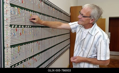 Teacher working on scheduling board for timetable, manpower planning-stock-foto