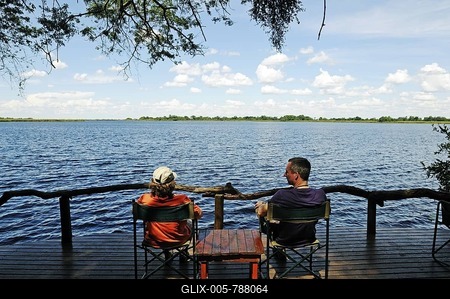 Tourists sitting on the terrace of a lodge on the Guma Lagoon, Okavango Delta, Botswana, Africa-stock-foto