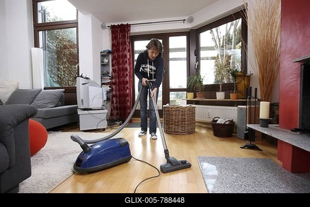 House work, woman hoovering in a flat-stock-foto