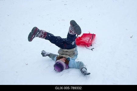 Girls rolling in the snow while sledding, Sonnenberg, St. Andreasberg, Lower Saxony, Germany-stock-foto