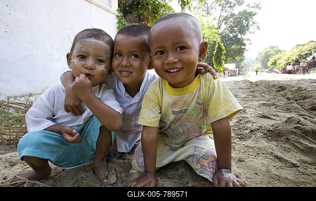 Three young boys squatting on a dusty road in Mingun, Mandalay, Myanmar (Burma), Southeast Asia-stock-foto