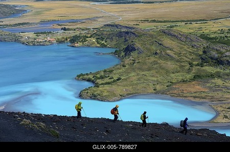 Hikers on a dark rock in front of the Rio Paine River, Patagonia, Chile, South America-stock-foto