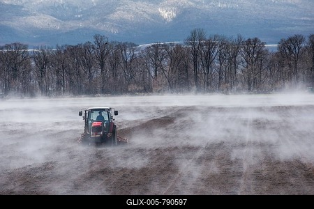 Tractor seeding a field while it is vaporating from the warm ground, Unesco world heritage site Shiretoko National Park, Hokkaido, Japan-stock-foto