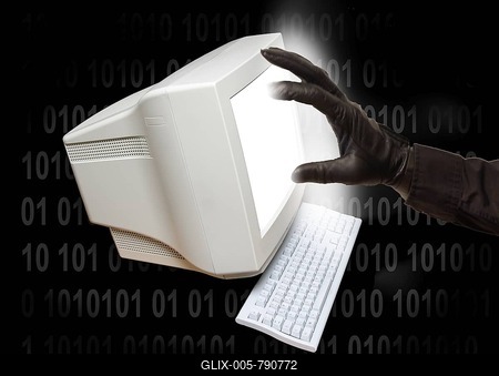 Hand with black glove reaches into a computer-stock-foto