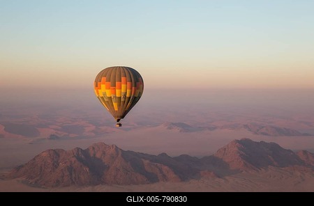 Hot-air balloon above an arid plain and isolated mountain ridges, at dawn, Namib Desert, aerial view from a second balloon, NamibRand Nature Reserve, Namibia-stock-foto