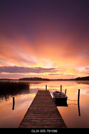 Sunrise at Lake Rheinberger, rowing boat moored beside pier, Rheinsberg, Brandenburg, Germany-stock-foto