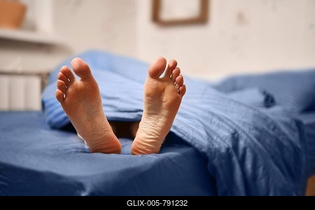 Soles of woman on the bed closeup-stock-foto