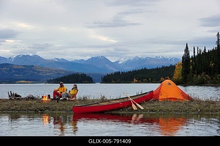 Couple around a campfire, canoeing, camping on the shore of a lake, Yukon Territory, Canada-stock-foto