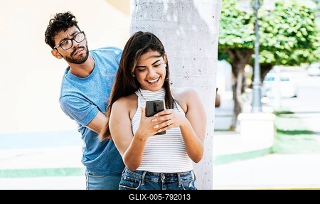 Jealous boyfriend spying on his girlfriend's cell phone in the park, Jealous man spying on his girlfriend texting on the cell phone. Suspicious man spying on his girlfriend with his cell phone-stock-foto