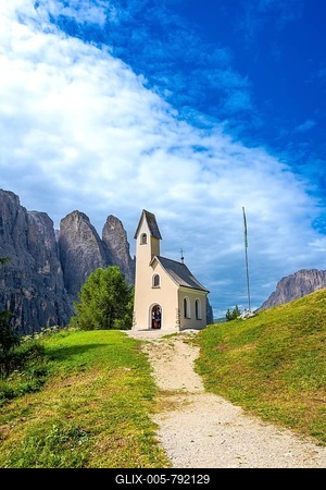 Small church at passo gardena with the dolomites in the background during a sunny summer day-stock-foto