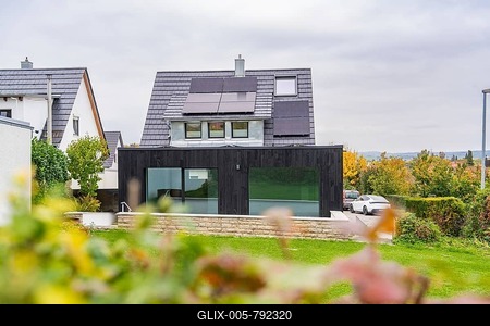 House with solar panels and black extension, view over garden to quiet street with parked car, house renovation, air conditioning renovation, Metzingen, Germany-stock-foto