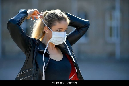 Woman putting on a face mask, portrait, corona crisis, Stuttgart, Baden-Württemberg, Germany-stock-foto