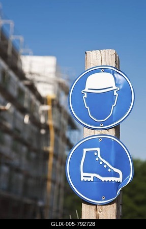 Information sign at the entrance to a building site to wear hard hats and safety shoes-stock-foto