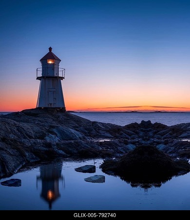 Lighthouse surrounded by rocks at night, lighthouse with lights on at sunset-stock-foto