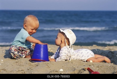 Two babies playing at the beach-stock-foto