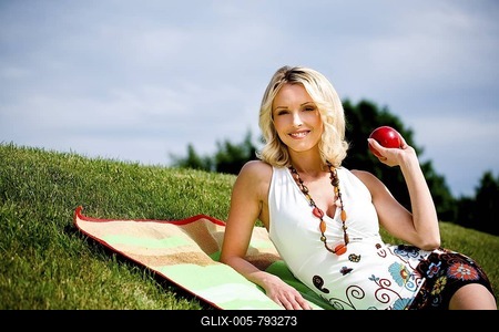 Young woman with apple in a meadow-stock-foto